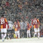 Players of Galatasaray and Juventus walk out of the pitch as their match is paused for 20 minutes due a heavy snowfall during their Champions League soccer match in Istanbul