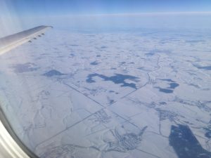 La campagna ucraina coperta di neve osservata dal finestrino di un aereo di linea