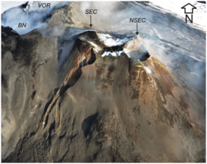 Visione aerea da Sud dell’area craterica sommitale dell’Etna. In primo piano, il Nuovo Cratere di Sud-Est (NSEC) accresciutosi recentemente sulla base orientale del più vecchio Cratere di Sud-Est (SEC).  In alto a sinistra, i crateri Voragine (VOR) e Bocca Nuova (BN). Foto di Marco Neri