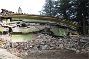 Amatrice: edificio collassato per il peso di coperture e solai in calcestruzzo armato e gravanti su murature fragili e vulnerabili, non progettate per sostenerli (Foto QUEST). 