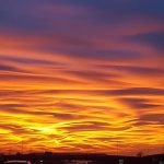 Il primo tramonto dell’ora solare è pura poesia: il sole tinge di rosso le nuvole e trasforma il cielo in un quadro mozzafiato [GALLERY]