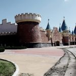 Un mondo sospeso – Wonderland, la Disneyland di Pechino mai completata: spighe di grano e agricoltori sullo sfondo di castelli fiabeschi [FOTO]